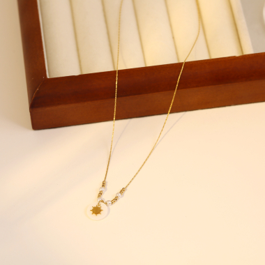 Großhändler Eclat Paris - Goldperlen- und Perlenkette mit Sonnenanhänger auf Perlmutt
