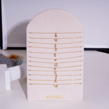Mayorista Eclat Paris - Conjunto de 12 collares de cadena de oro con colgantes en exposición.